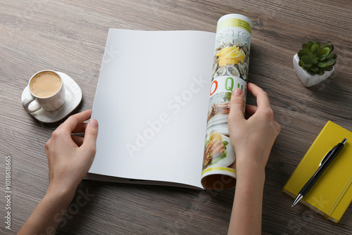 Woman reading magazine at wooden table, closeup. Mockup for design