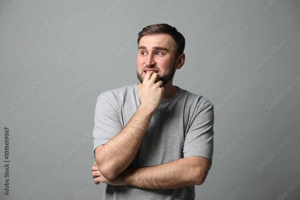Young man feeling fear on grey background Young man feeling fear on grey background