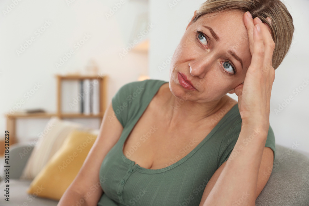 Menopause. Woman suffering from headache on sofa at home Menopause. Woman suffering from headache on sofa at home