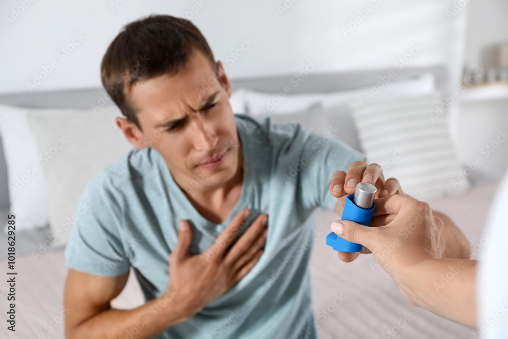 Man getting asthma inhaler at home, selective focus Man getting asthma inhaler at home, selective focus