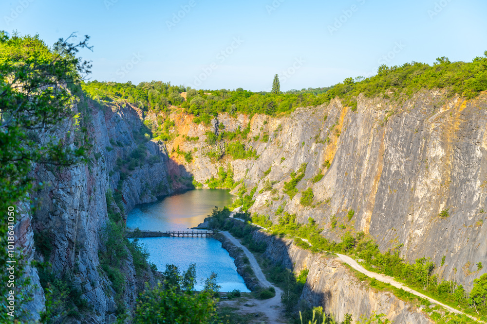 Φωτογραφία The picturesque Velka Amerika Quarry in Czechia showcases its stunning cliffs and tranquil blue waters under a morning sun