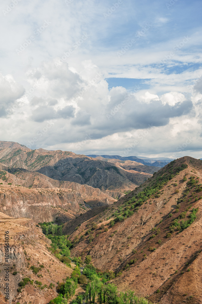 Obraz premium Majestic mountains under a blue sky filled with clouds, showcasing natural beauty and rugged terrain