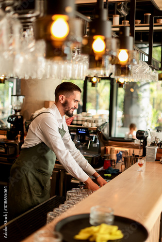 Obraz na płótnie Cheerful bartender prepares cocktails in a stylish urban bar filled with natural
