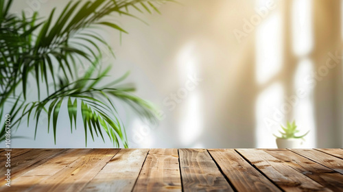 Wooden table with tropical leaves in sunlit room. Copy space 