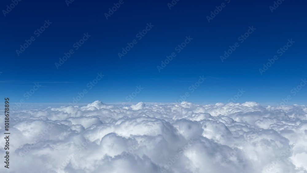 Fototapeta premium Fluffy white clouds float against a vibrant blue sky, illustrating freedom and tranquility, perfect for relaxation and meditation themes
