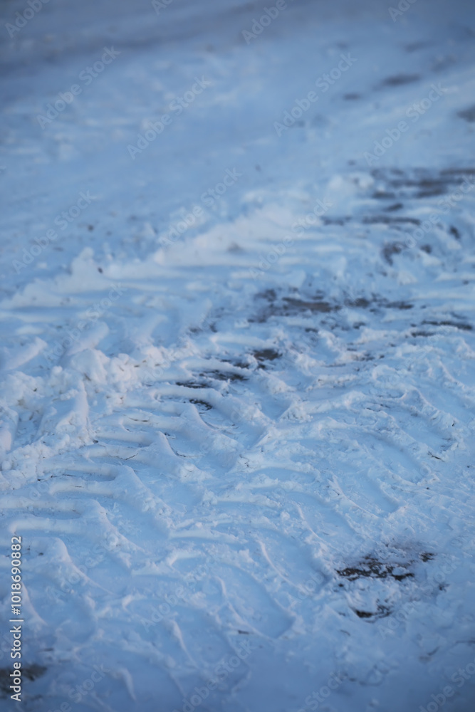 Fototapeta premium Snowy Terrain with Tire Tracks and Ice in Winter Landscape