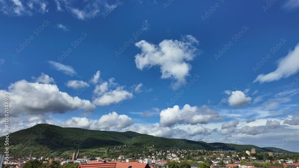 A clear blue sky with a few clouds and a mountain in the background A clear blue sky with a few clouds and a mountain in the background