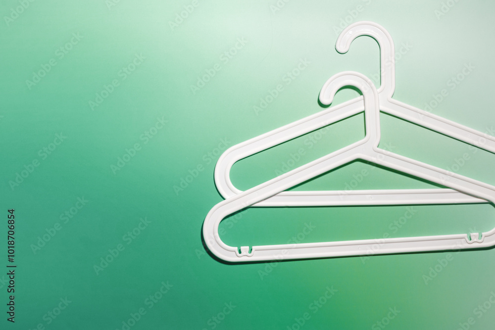 Top view White Plastic hangers, minimal style layout on white green gradient background, Clothes rack for organizing clothes in closets or retail stores, fashion, organization concept, copyspace Top view White Plastic hangers, minimal style layout on white green gradient background, Clothes rack for organizing clothes in closets or retail stores, fashion, organization concept, copyspace