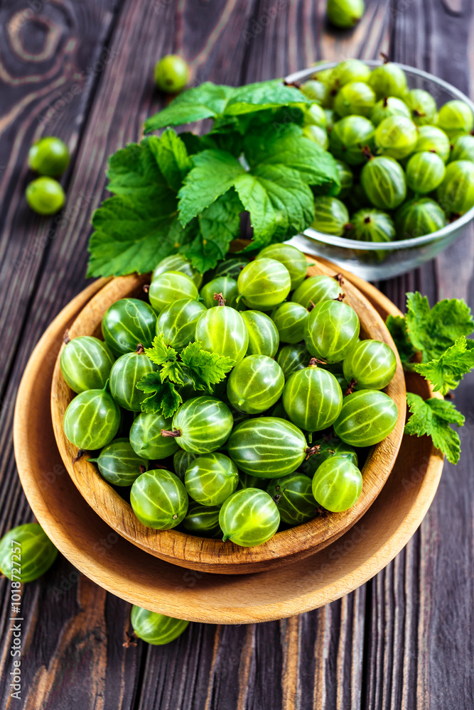 Green Organic Berries Gooseberries.Green gooseberries in a wooden bowl.Gooseberries on the wooden table. Harvest concept. Vegetarian food. Green Organic Berries Gooseberries.Green gooseberries in a wooden bowl.Gooseberries on the wooden table. Harvest concept. Vegetarian food.