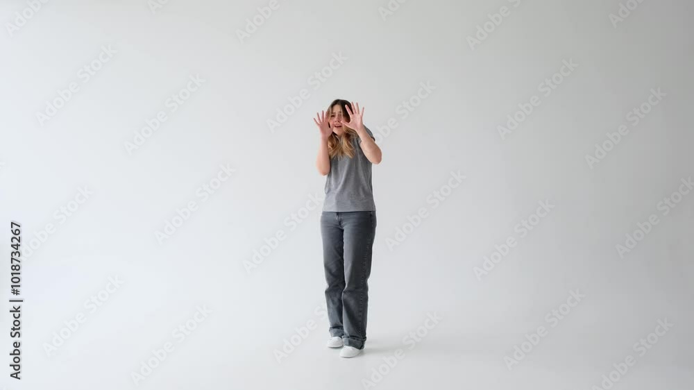 Scared and frightened young adult Caucasian woman in panic, standing alone on white background. Concept of an emotional stress, shock and horror. Scared and frightened young adult Caucasian woman in panic, standing alone on white background. Concept of an emotional stress, shock and horror.