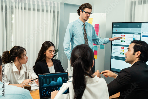 Project manager planning schedules for business task at meeting room, Gantt chart software show on TV screen. Multi ethnic diversity business people and modern business project management. Habiliment