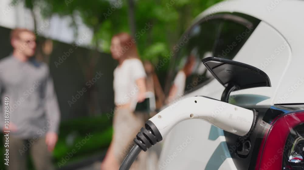 Slow motion focused EV electric car charging in green sustainable city outdoor garden in summer show lifestyle on blur background of couple as clean rechargeable for urban electric vehicle innards Slow motion focused EV electric car charging in green sustainable city outdoor garden in summer show lifestyle on blur background of couple as clean rechargeable for urban electric vehicle innards