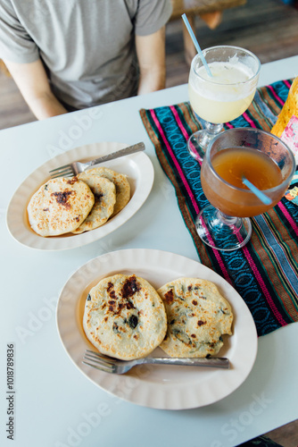 Plates of papusas and large cups of juice on a table in Belize