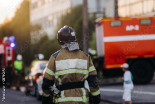 Group of fire men in uniform during fire fighting operation in the city streets, firefighters with the fire engine truck vehicle in the background, emergency and rescue, fire drill, exercise training