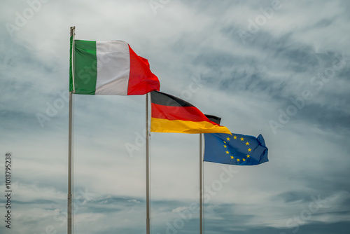 The Italian and German flags next to the European Union flag to symbolize the friendship between the two nations and post-war reconciliation. Futa pass, Firenzuola, Florence, Tuscany, Italy photo