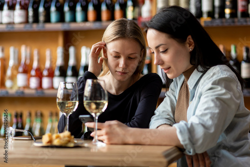 Two women chatting with glasses of wine photo