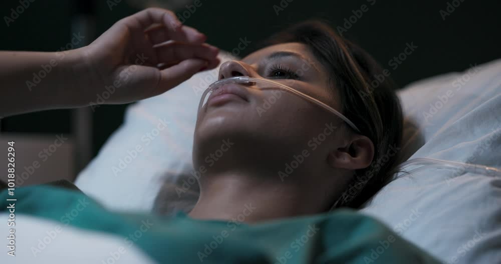 Young woman lying in hospital bed with oxygen tube in her nose. Young woman lying in hospital bed with oxygen tube in her nose.