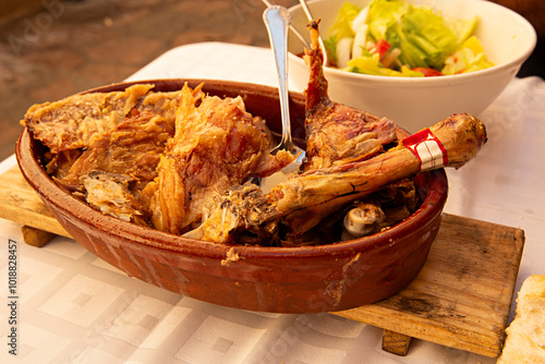 Fuente de barro con cordero lechal asado al horno de leña. photo