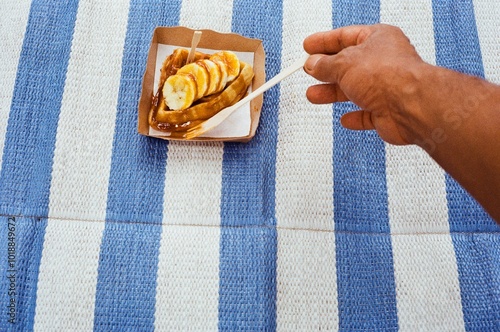 Hand reaching for dessert on a blue mat photo