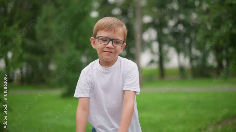 A young boy with glasses happily runs forward, but his expression changes to one of seriousness as he approaches his bicycle, wearing a white shirt and denim shorts A young boy with glasses happily runs forward, but his expression changes to one of seriousness as he approaches his bicycle, wearing a white shirt and denim shorts