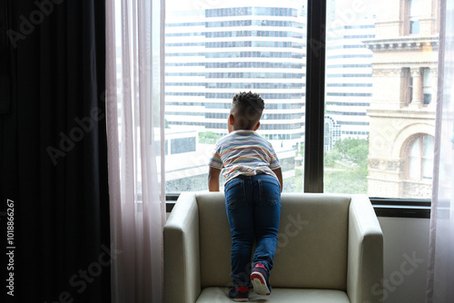 Child Looking Out Hotel Window photo