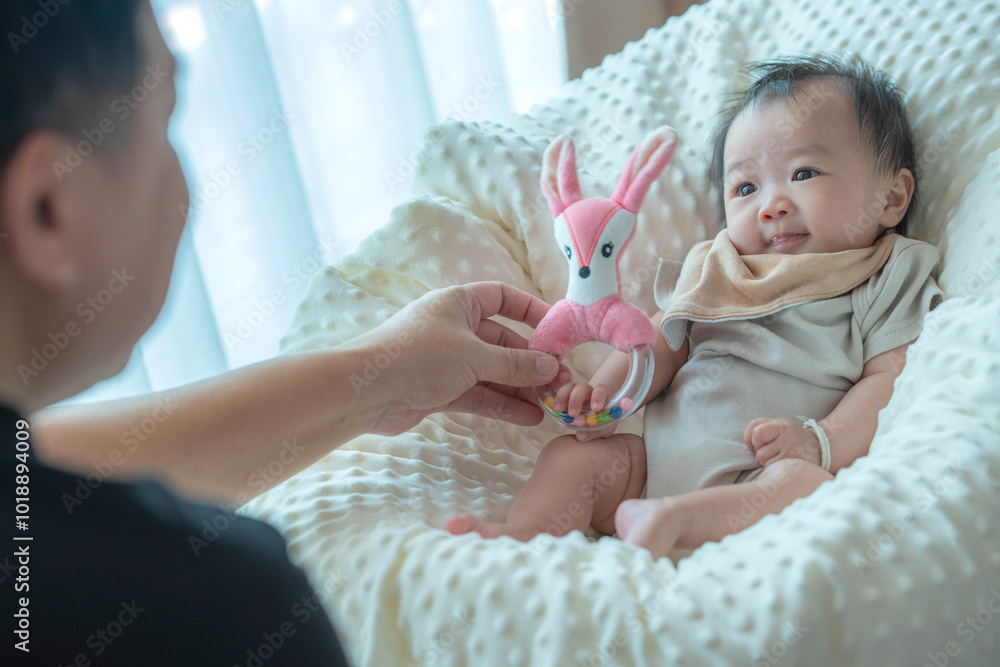 Baby Playing with Pink Toy While Relaxing in Cozy Blanket Baby Playing with Pink Toy While Relaxing in Cozy Blanket