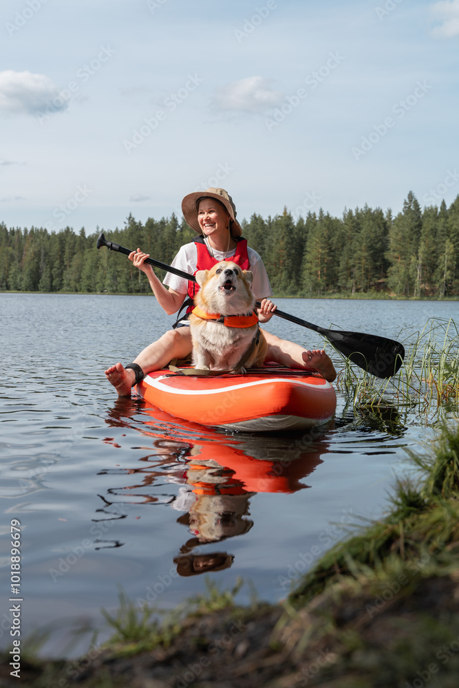Woman and Corgi Enjoying SUP Adventure on Lake Woman and Corgi Enjoying SUP Adventure on Lake