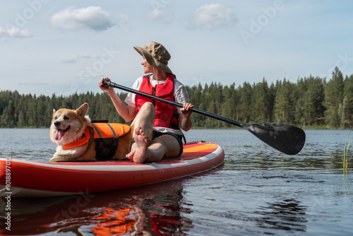 Woman Paddling on SUP Board with Corgi