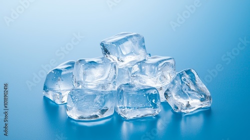 Clear ice cubes stacked on a reflective surface with a blue background in natural lighting