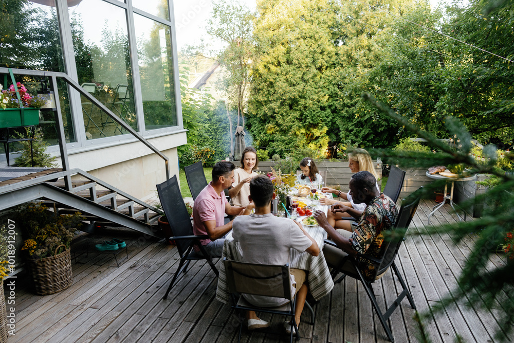 Happy friends and relatives resting and having lunch on terrace Happy friends and relatives resting and having lunch on terrace