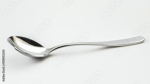 A shiny stainless steel spoon rests on a plain white background, showcasing its sleek design and smooth surface