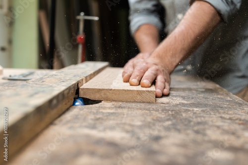 A carpenter is milling an oak plank