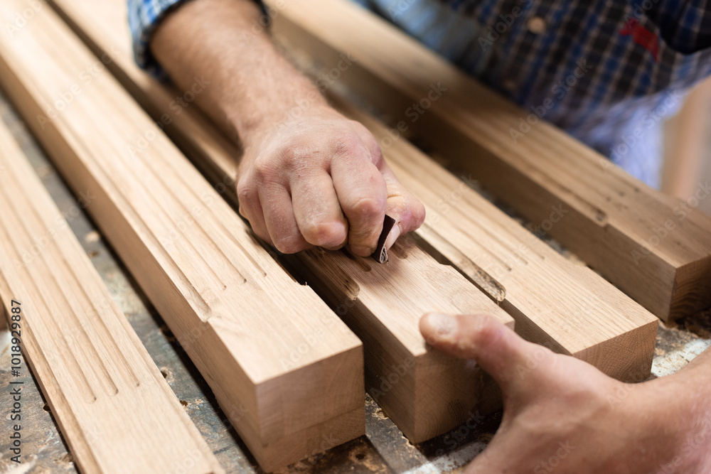 The carpenter sanded fine details in the oak part with sandpaper The carpenter sanded fine details in the oak part with sandpaper