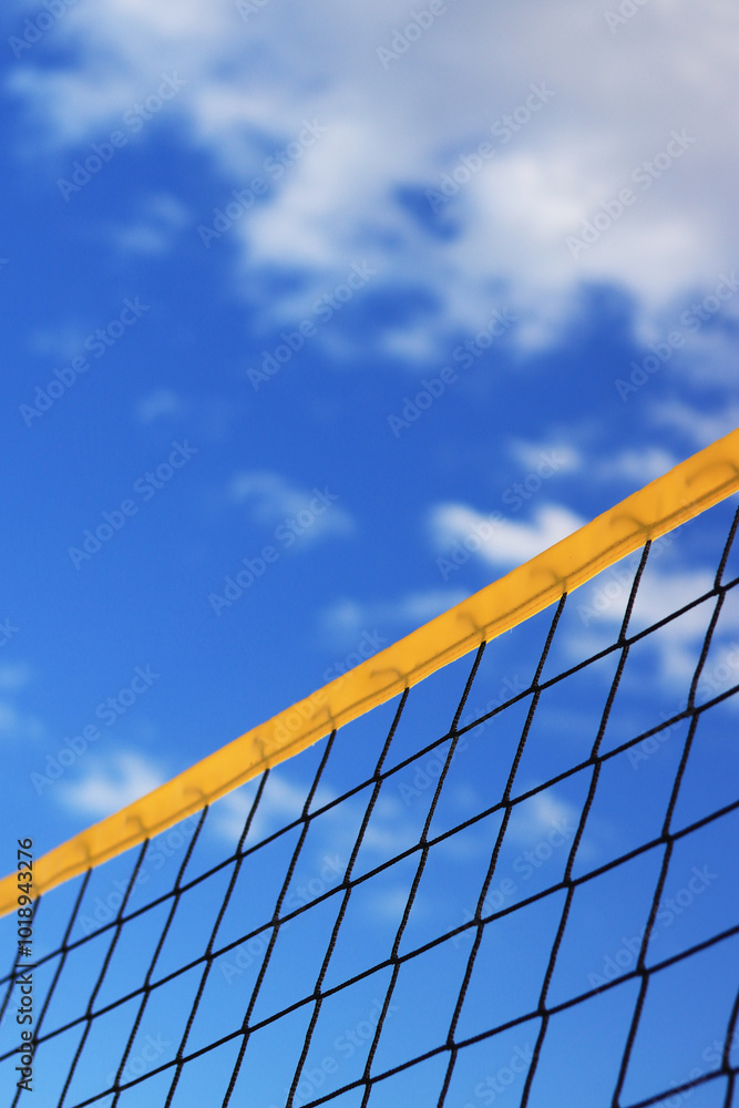 Beach volleyball net close-up. Fragment of a volleyball net on the beach against the blue sky. Sport, beach volleyball. Active recreation concept. Background. Detail of the yellow net. Sports ground Beach volleyball net close-up. Fragment of a volleyball net on the beach against the blue sky. Sport, beach volleyball. Active recreation concept. Background. Detail of the yellow net. Sports ground