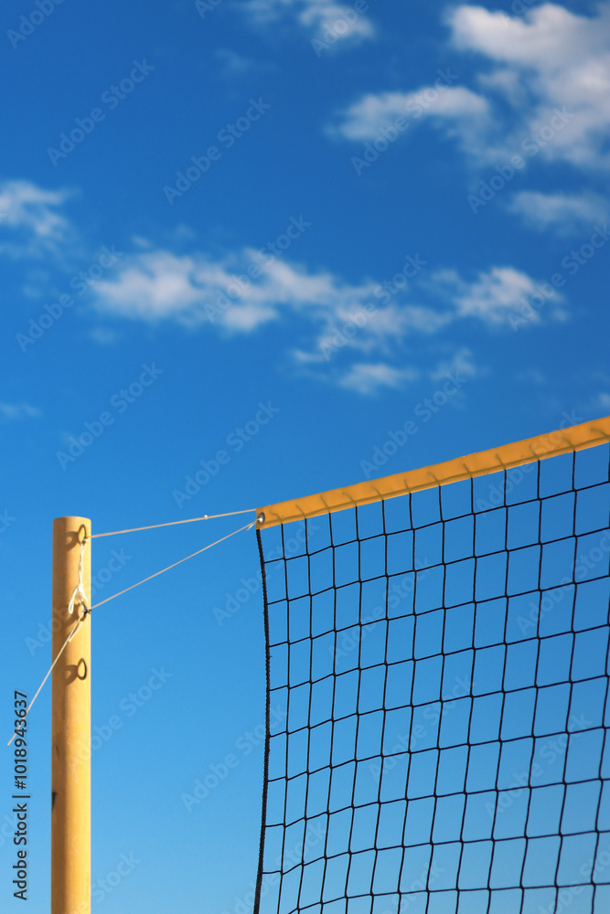 Beach volleyball net close-up. Fragment of a volleyball net on the beach against the blue sky. Sport, beach volleyball. Active recreation concept. Background. Detail of the yellow net. Sports ground Beach volleyball net close-up. Fragment of a volleyball net on the beach against the blue sky. Sport, beach volleyball. Active recreation concept. Background. Detail of the yellow net. Sports ground
