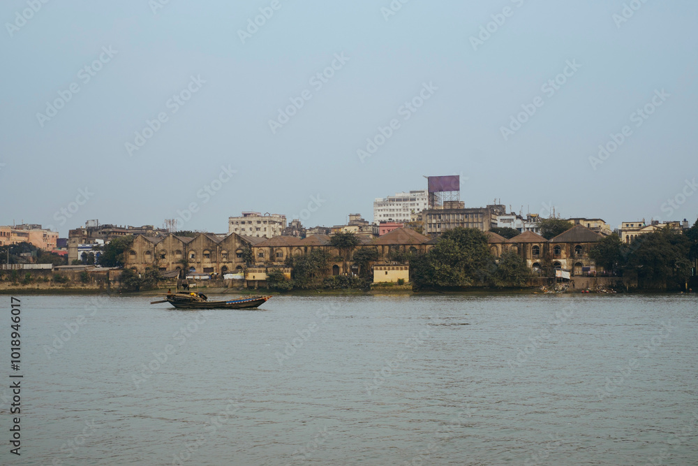 Boat gliding on river near old buildings at dusk in a city Boat gliding on river near old buildings at dusk in a city