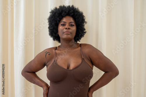 Confident Curvy Woman In Dark Brown Bodysuit Posing photo