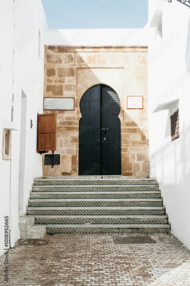 Naklejka premium un escalier menant a une porte noire.