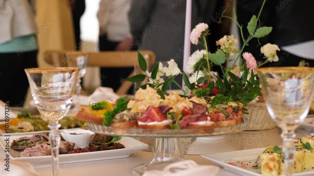 Guests wait to be invited to a buffet table with appetizers and an assortment of dishes in slow motion. Guests wait to be invited to a buffet table with appetizers and an assortment of dishes in slow motion.