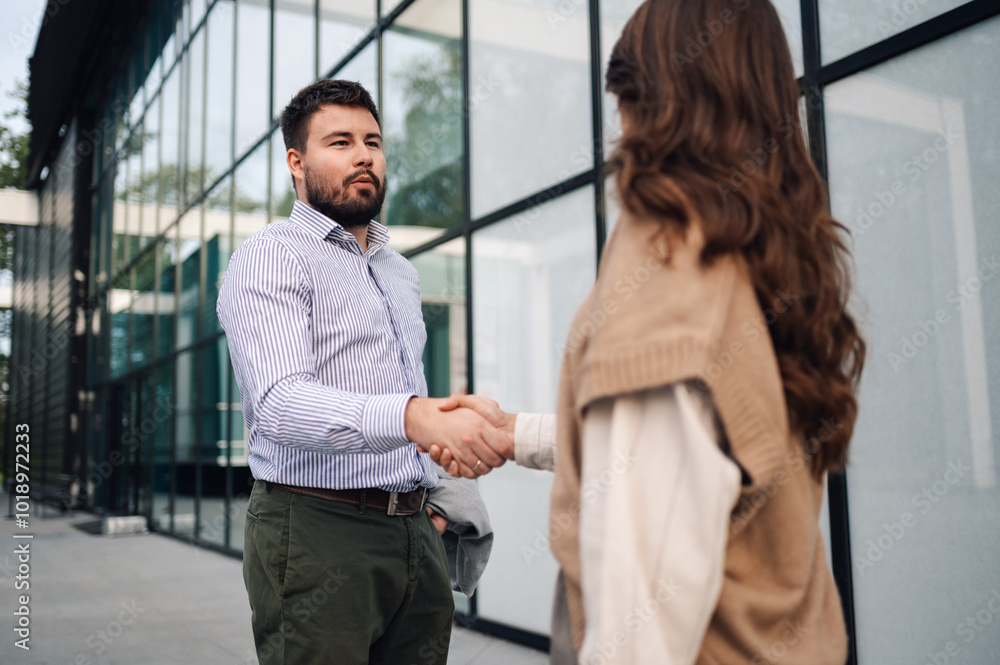 Business people shaking hands outside office building Business people shaking hands outside office building