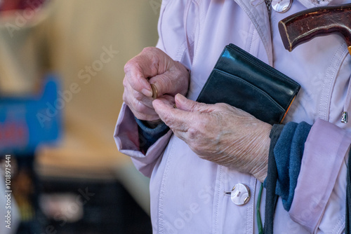 Pensioner counting money into her purse. Close up of hands. Poor pensioner concept. photo