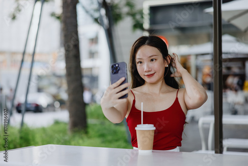 Woman Taking Selfie at Outdoor Café photo