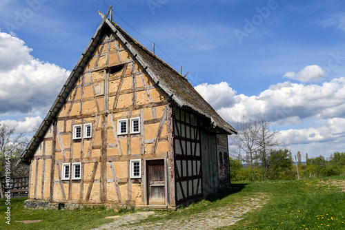 A traditional German half timbered house stands under a blue sky, photo