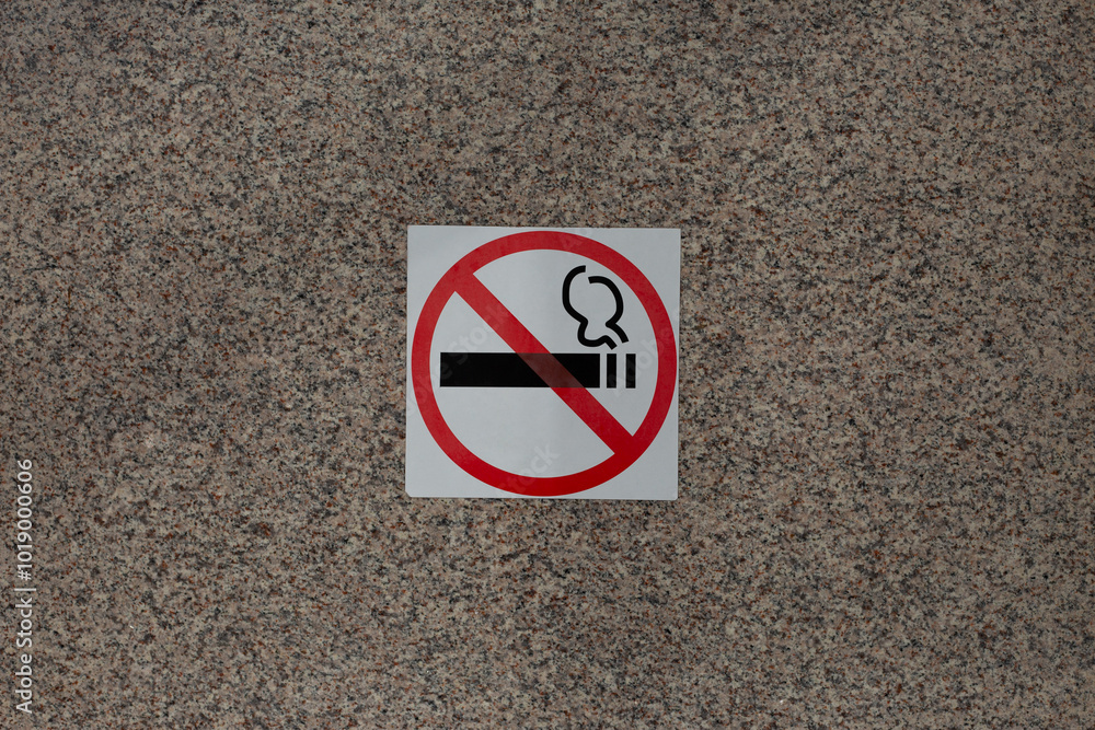 Sticker with crossed out cigarette on marble wall of building, ban on smoking in public place with special sign, social problem and smoking addiction Sticker with crossed out cigarette on marble wall of building, ban on smoking in public place with special sign, social problem and smoking addiction
