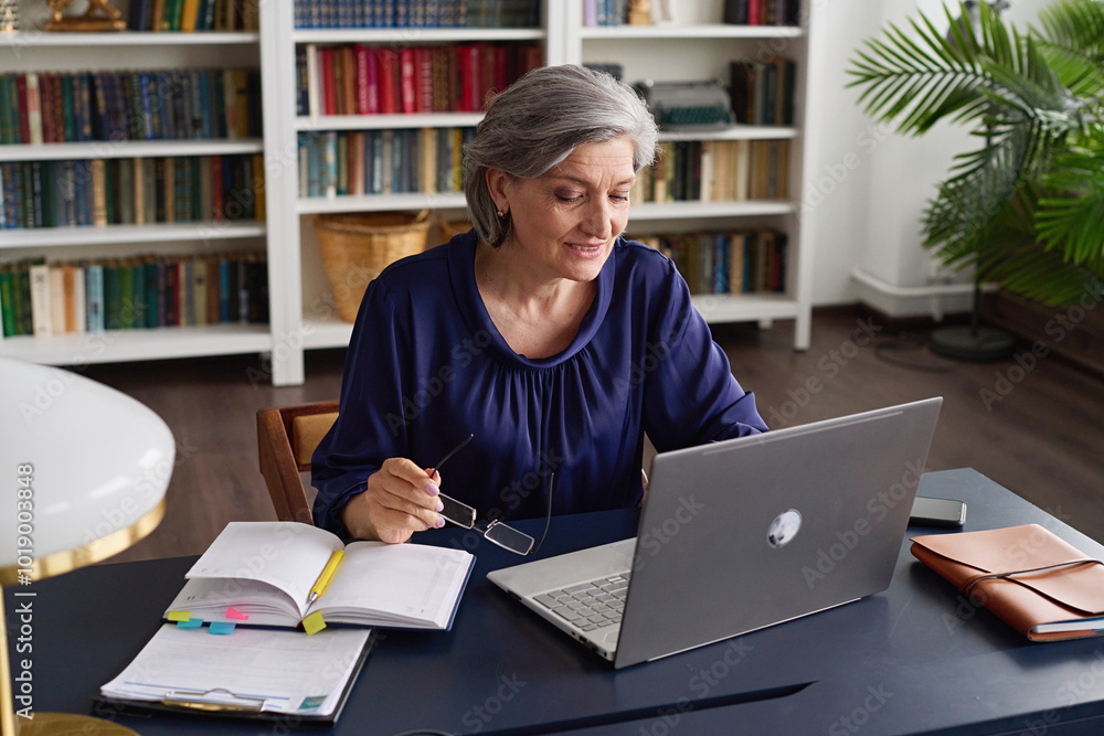 Senior Woman Working on Laptop in Cozy Home Office Senior Woman Working on Laptop in Cozy Home Office