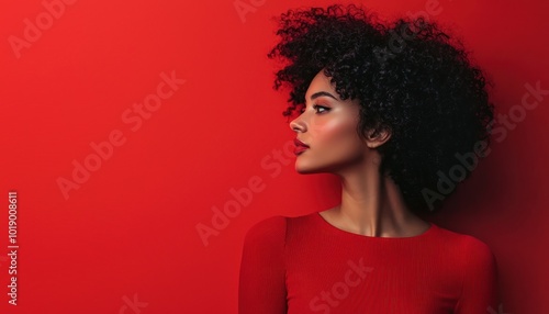 Woman in a striking red top against a red background, bold and assertive.