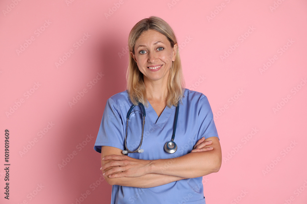 Portrait of doctor in medical uniform with stethoscope on pink background Portrait of doctor in medical uniform with stethoscope on pink background