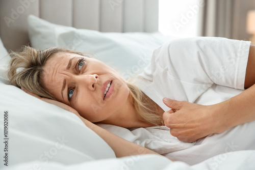 Menopause. Woman suffering from hot flash in bed at home