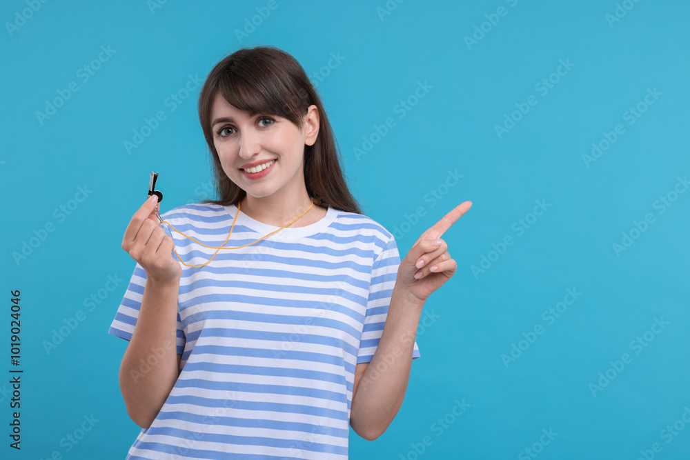 Happy woman with whistle on light blue background, space for text Happy woman with whistle on light blue background, space for text