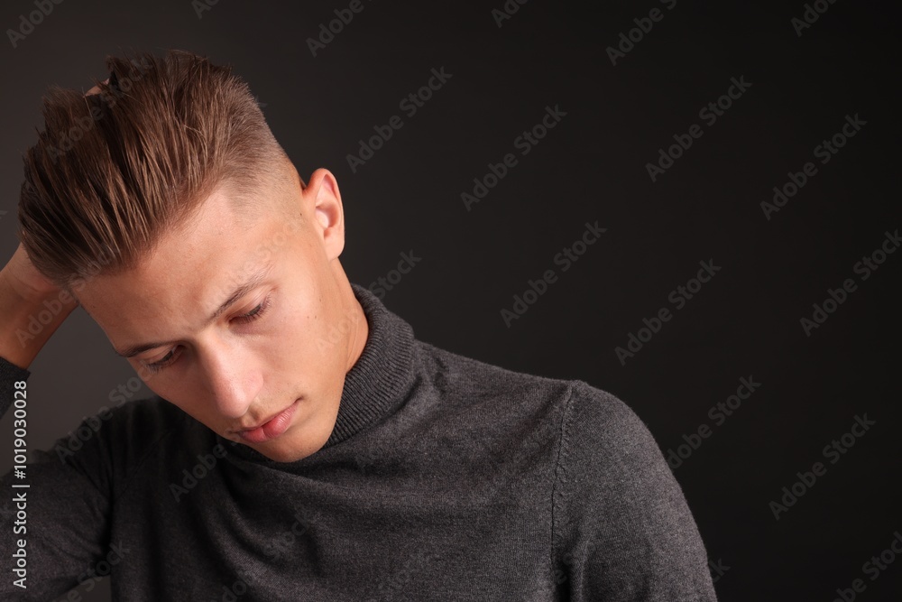 Confident young man with stylish haircut on black background. Space for text Confident young man with stylish haircut on black background. Space for text